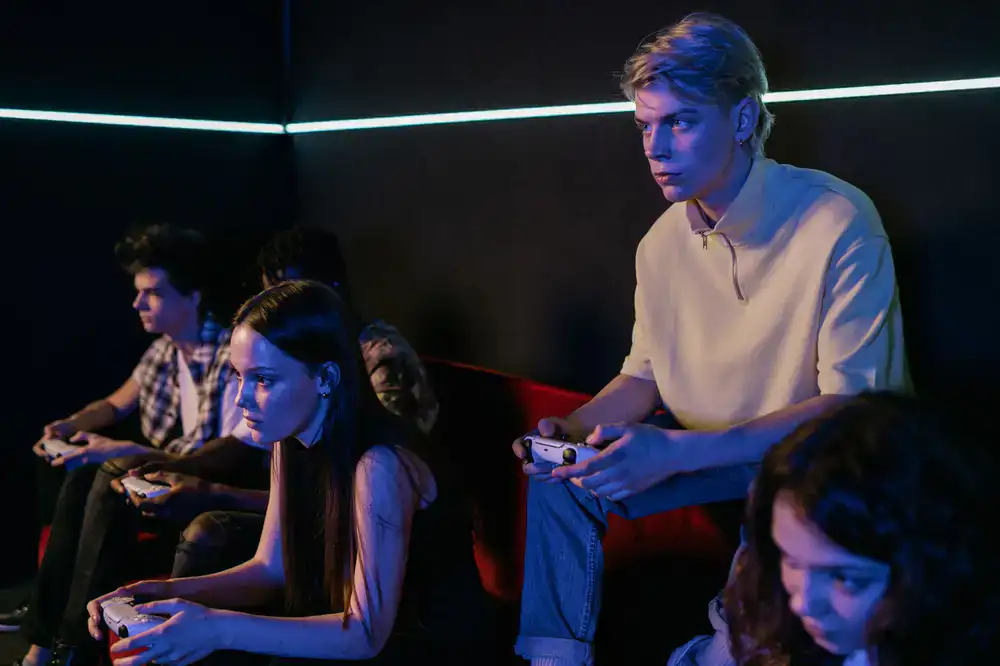 Group of friends playing console games on a couch
